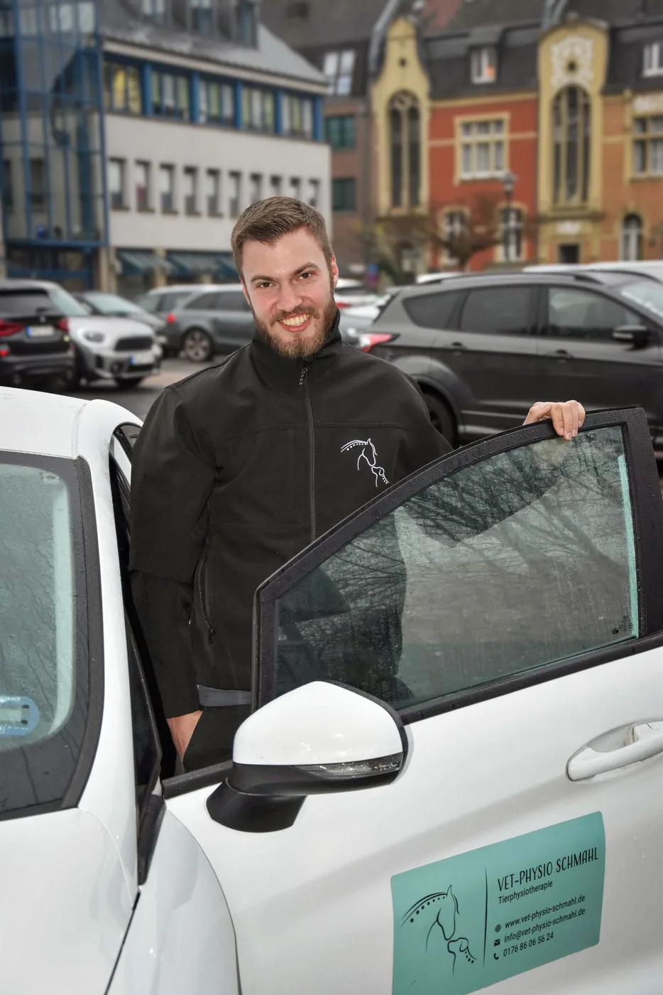 Businessporträt eines Mannes an seinem Firmenwagen