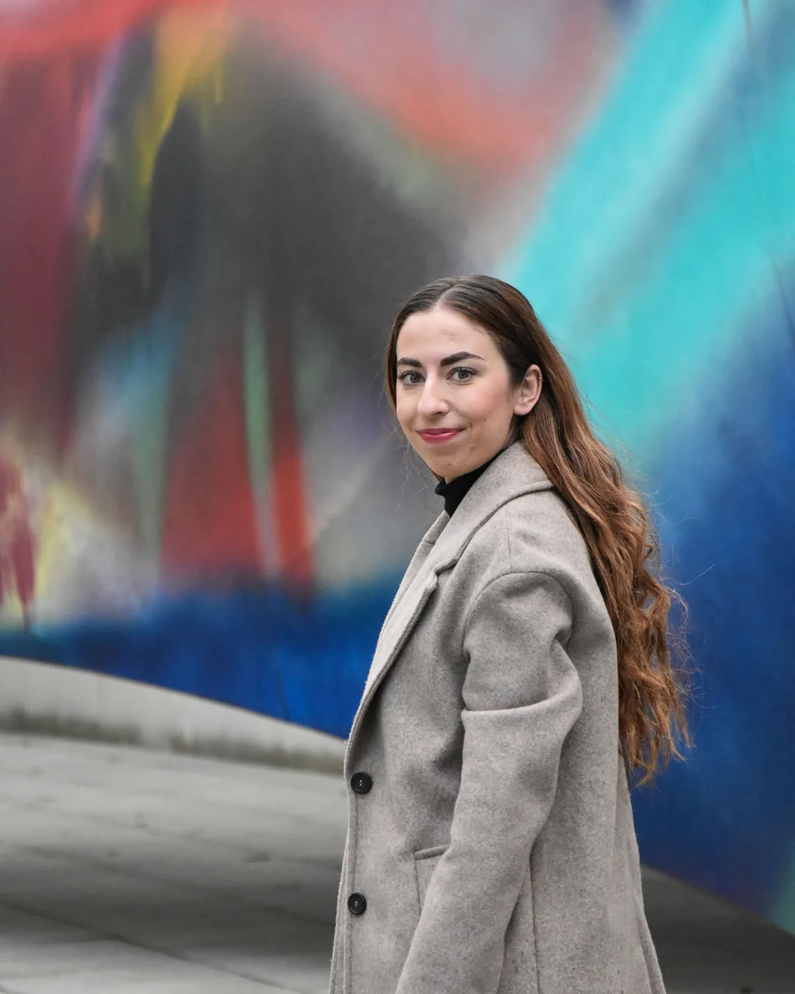 Lifestyleporträt einer Frau vor bunter Wand
