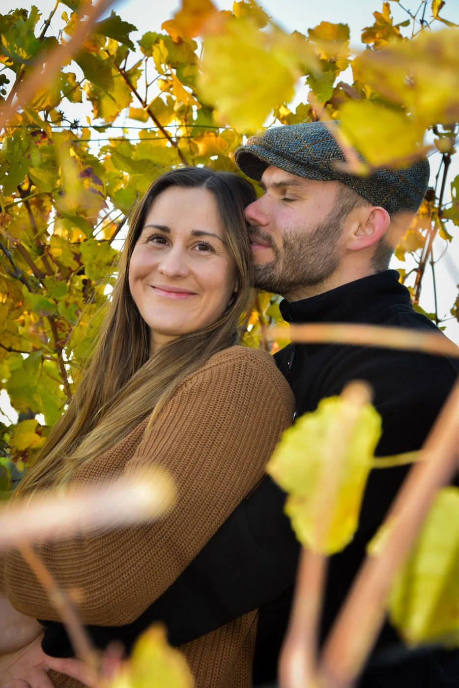 Paar umarmt sich zärtlich im herbstlichen Weinberg